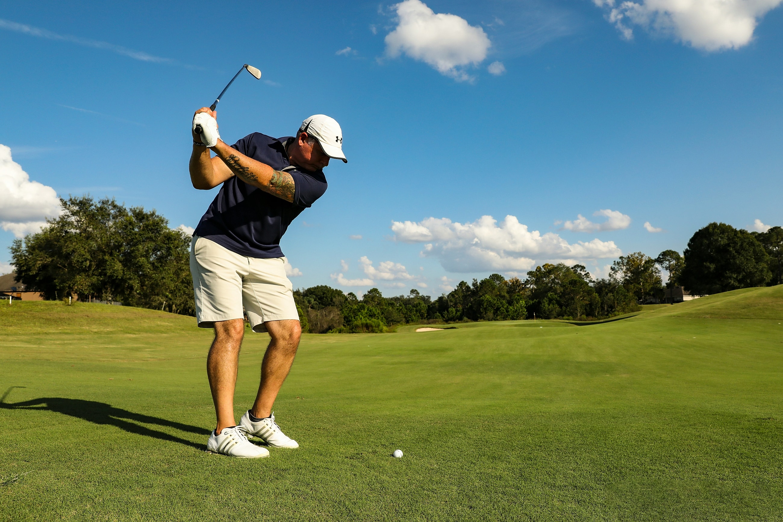 Golfer preparing to tee off on sunny day.