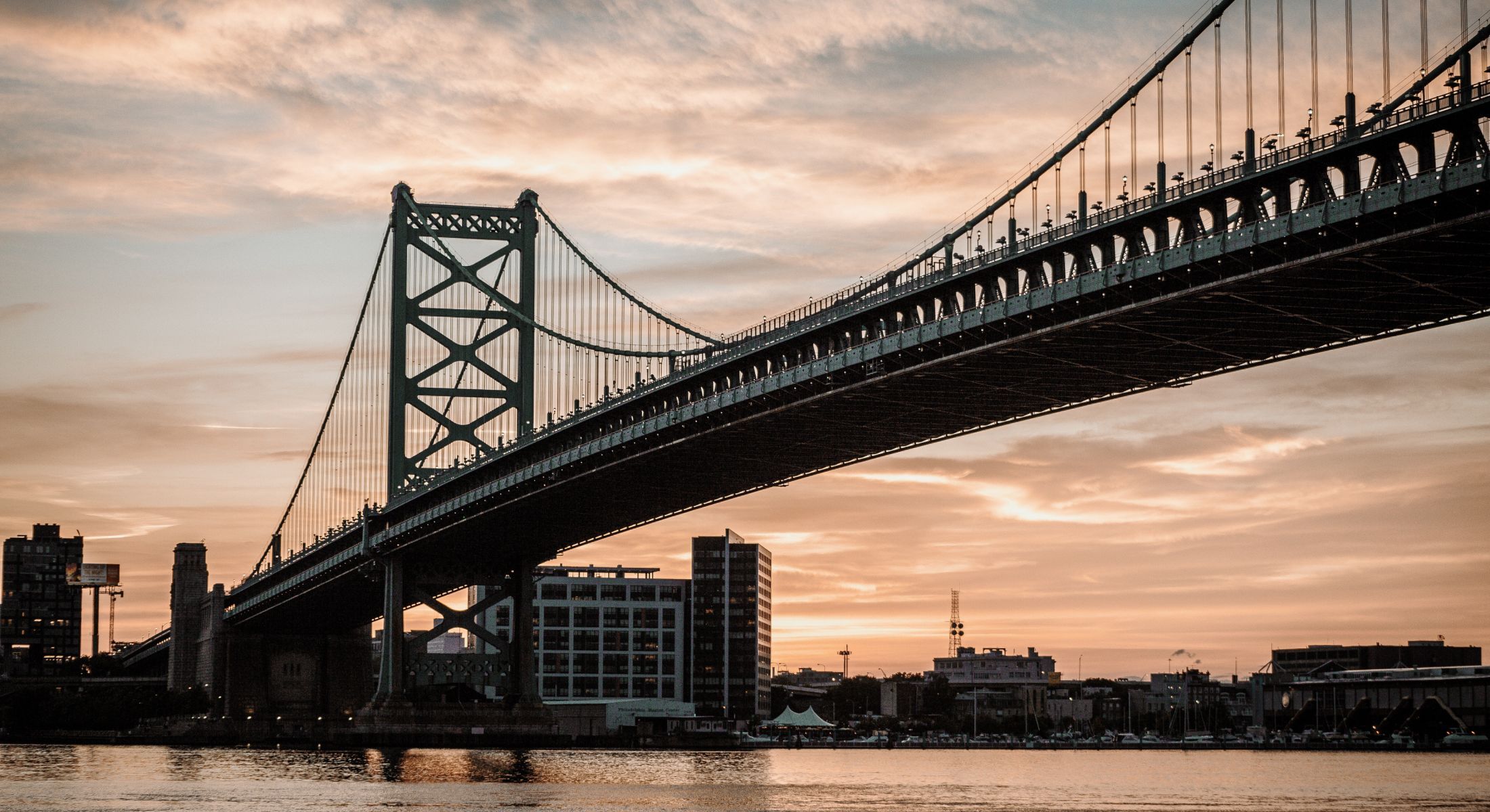 photo of a bridge in front of a sunset